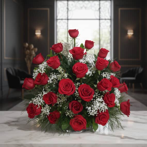 Arreglo floral 'Me Tienes Loco' con rosas rojas frescas y follaje verde, sobre una mesa de mármol en un elegante lobby de hot