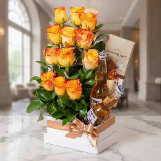 Arreglo floral Zeus con rosas amarillas y naranjas, dos cervezas Corona y chocolates Montblanc en un elegante fondo de lobby
