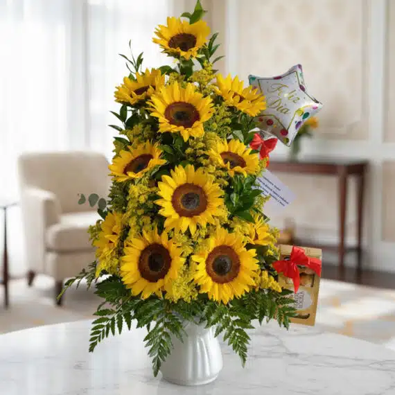 Arreglo con Girasoles Halo: Elegancia y Frescura para Toda Ocasión Arreglo floral premium con girasoles vibrantes y follaje verde, presentado en un jarrón blanco sobre una mesa de mármol en un