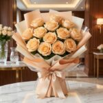 Bouquet de 12 rosas Celestina color melocotón en empaque coreano, sobre mesa de mármol en un ambiente elegante de floristería